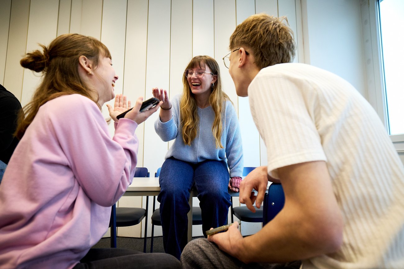 Schüler sitzen auf Tisch und unterhalten sich 