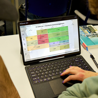 Schüler schaut auf Stundenplan am Tablet