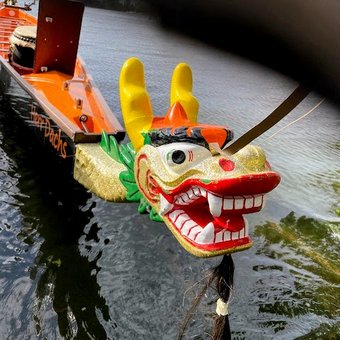 ein bunter Drachenkopf am Bug eines Schiffes