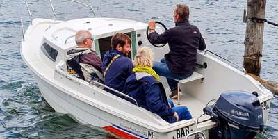 Motorboot auf einem see mit vier Menschen darin