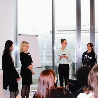 Schüler stehen vor einem Flipchart