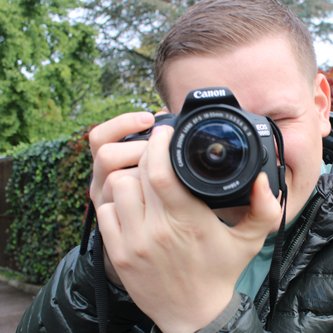 Mann mit Kamera vor dem Gesicht