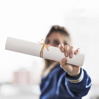 Frau zeigt Rolle mit Zertifikat