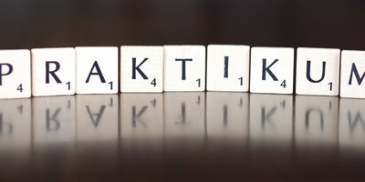 Scrabbel-Buchstaben-Plättchen, die das Wort "Praktikum" bilden