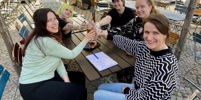 vier ehemalige Schülerinnen und eine Lehrerin stoßen lachend miteinander an