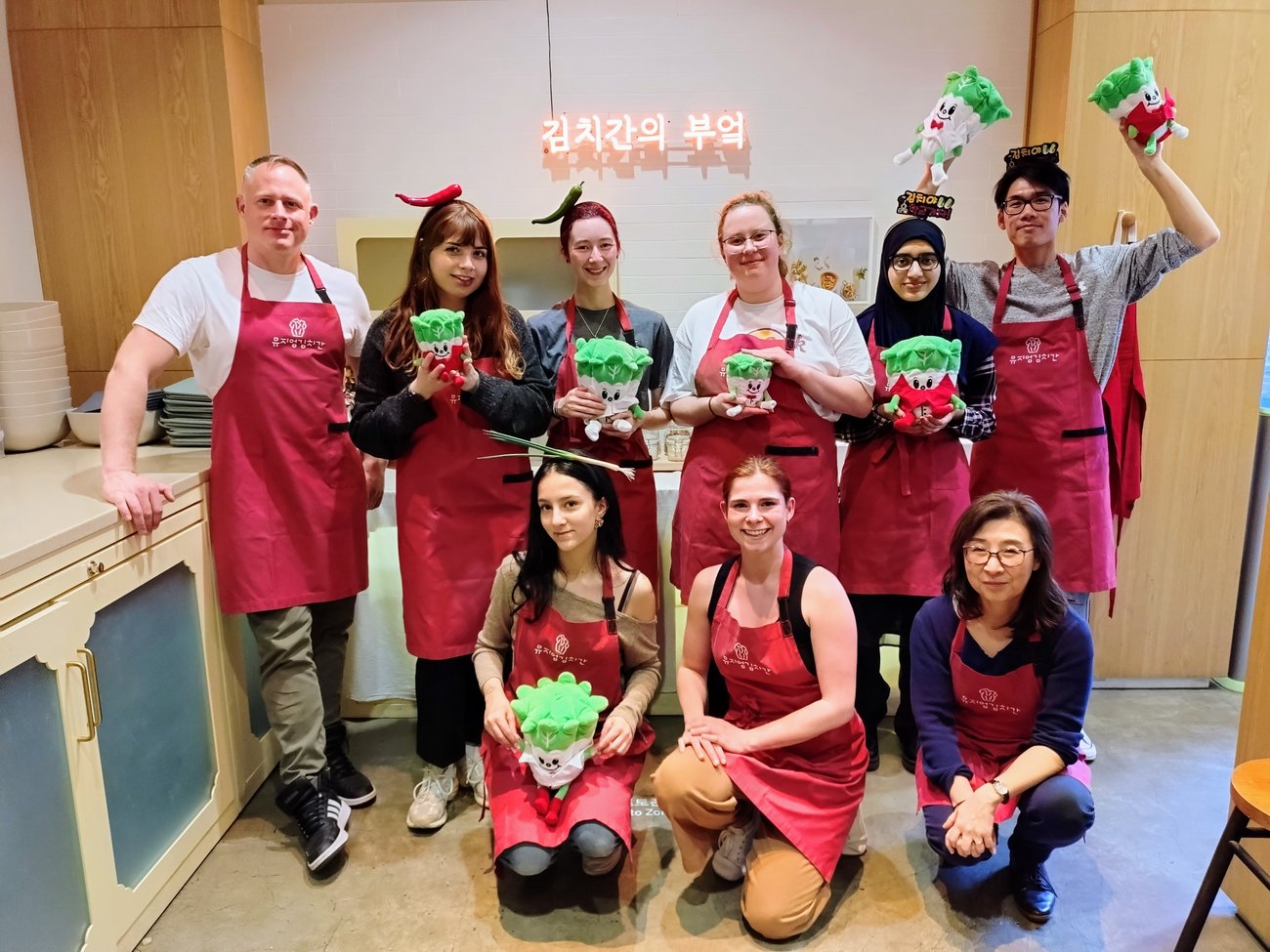 Gruppe von Schülern mit einem Lehrer in roten Schürzen