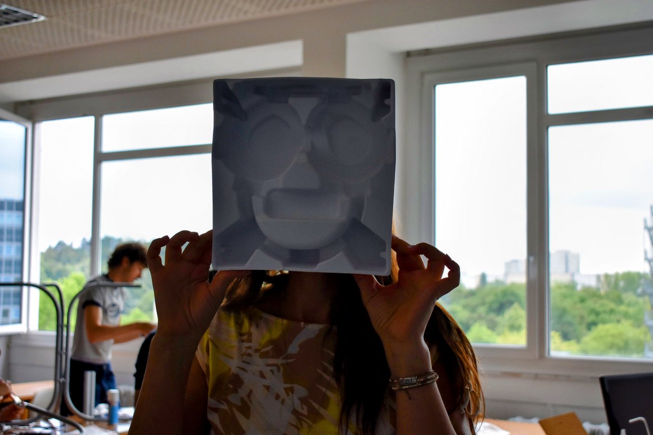 Gesicht von Schülerin hinter gemaltem Gesicht