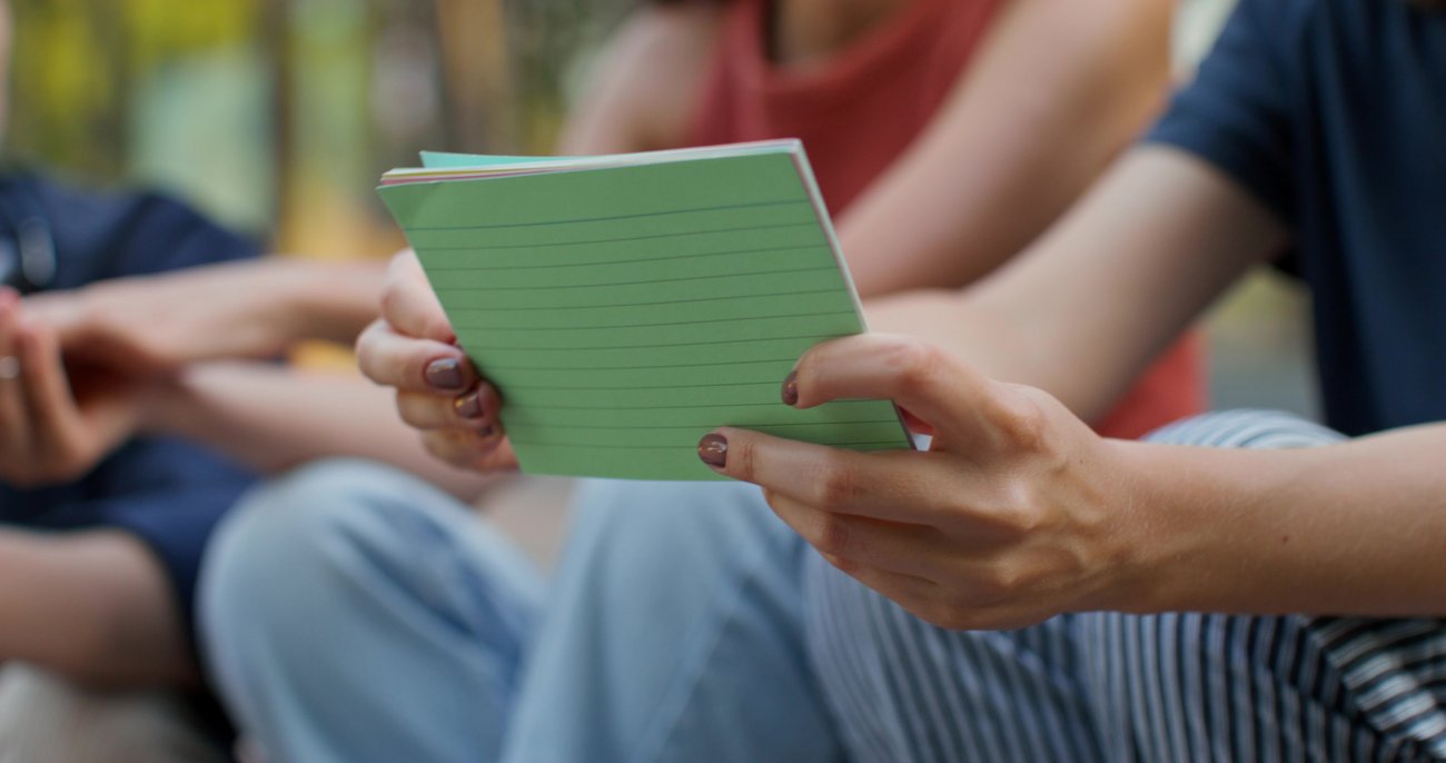 Schülerin hält Karteikarten