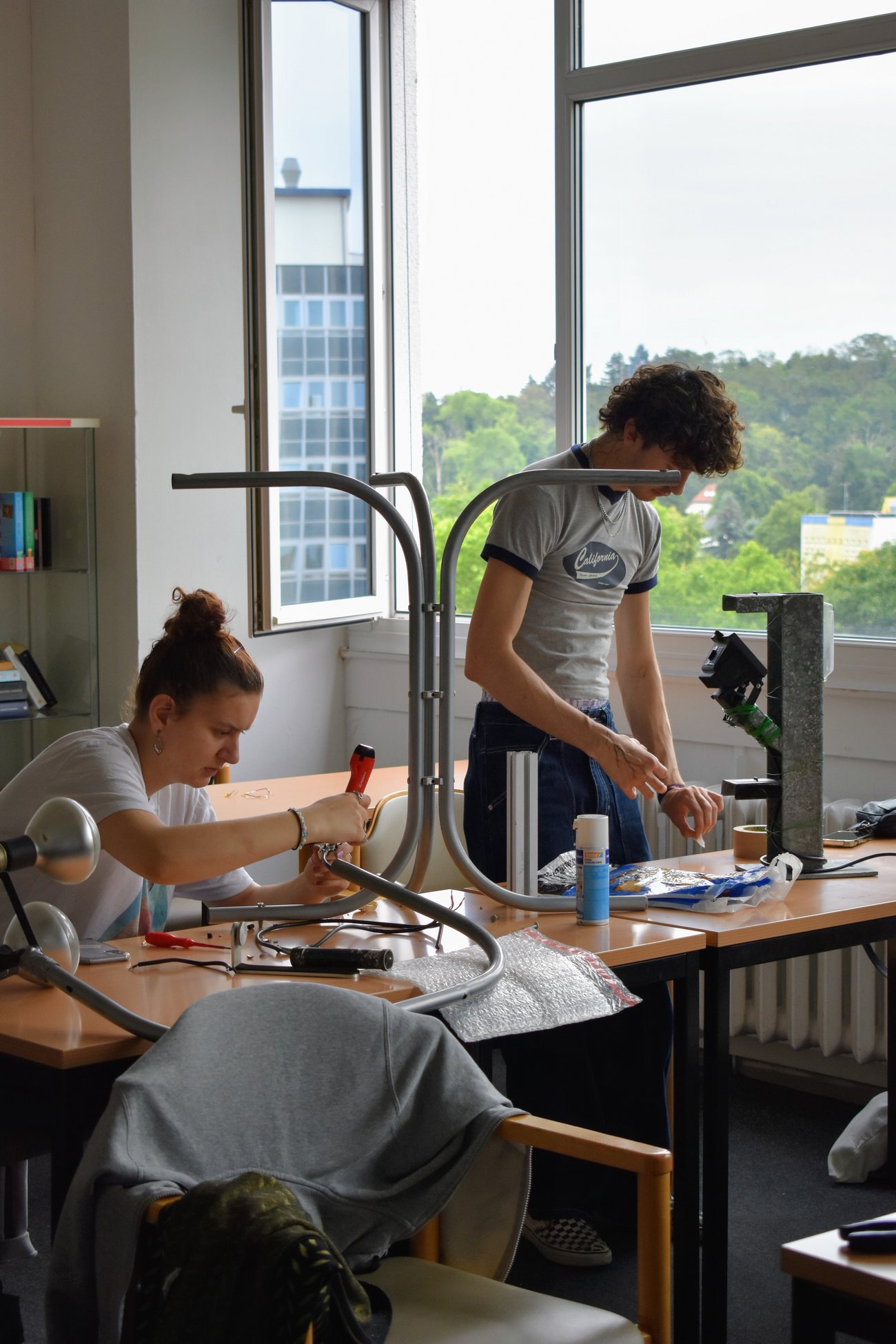 eine Schülerin und ein Schüler arbeiten jeder für sich an einem Projekt