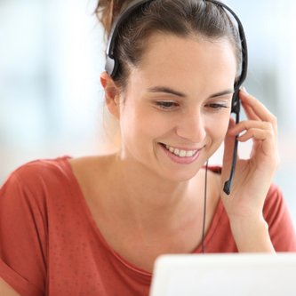 Beraterin spricht am Headset vor Laptop