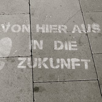 Kreidemalerei auf Pflastersteinen mit Fußabdrücken