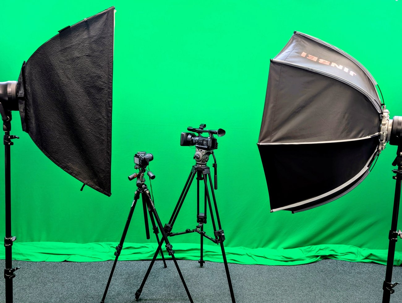 Zwei Kameras und zwei Softboxen vor einer grünen Wand