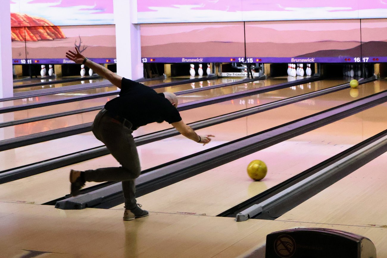 ein Mann beim abstoß der Bowlingkugel