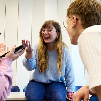 Schüler sitzen auf Tisch und unterhalten sich 