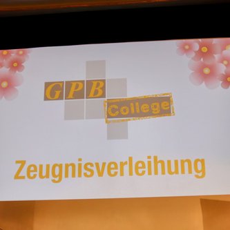 große Leinwand mit dem Text Zeugnisverleihung und dem Logo vom GPB College