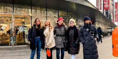 eine Lehrerin mit vier Schülerinnen vor der Galerie Lafayette