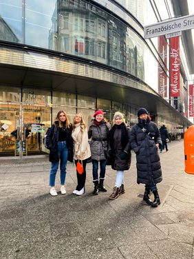 eine Lehrerin mit vier Schülerinnen vor der Galerie Lafayette