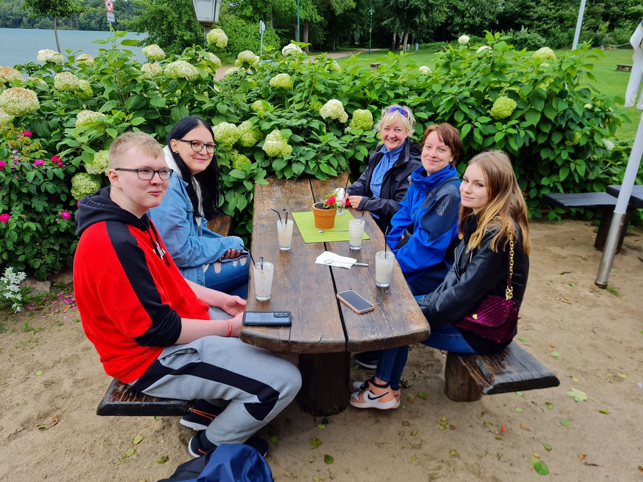 Schüler sitzen an eine Holztisch, auf dem Getränke stehen