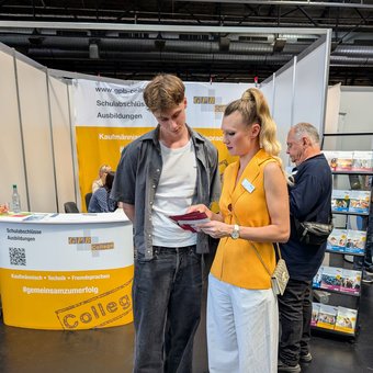 zwei Menschen vor unserem Messestand auf der Vocatium