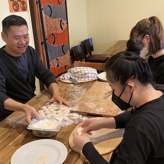 3 Personen an einem Tisch, die Essenzubereiten