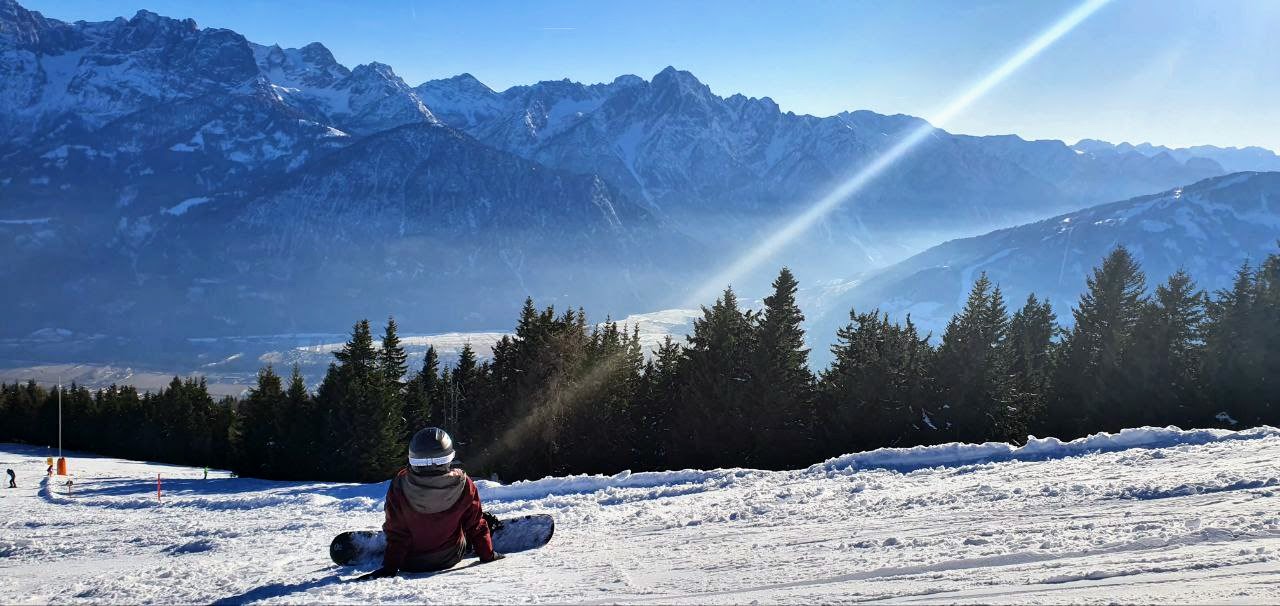 ein Snowboarder vor Bergkulisse